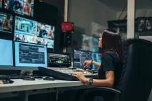 Frau arbeitet im Kontrollraum eines TV-Senders
